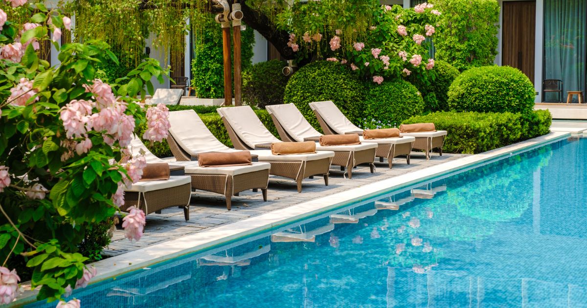 five star hotel pool with deck chairs beside it