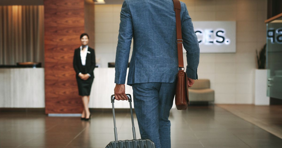 man walking to a hotel check-in desk